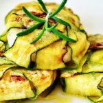Delicious zucchini wraps stuffed with grilled chicken, presented with fresh rosemary garnish.