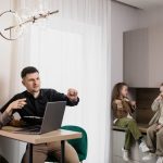Family discussing real estate purchase inside home with agent and children present.